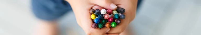 Ett barn som håller en handfull kritor i sina händer.